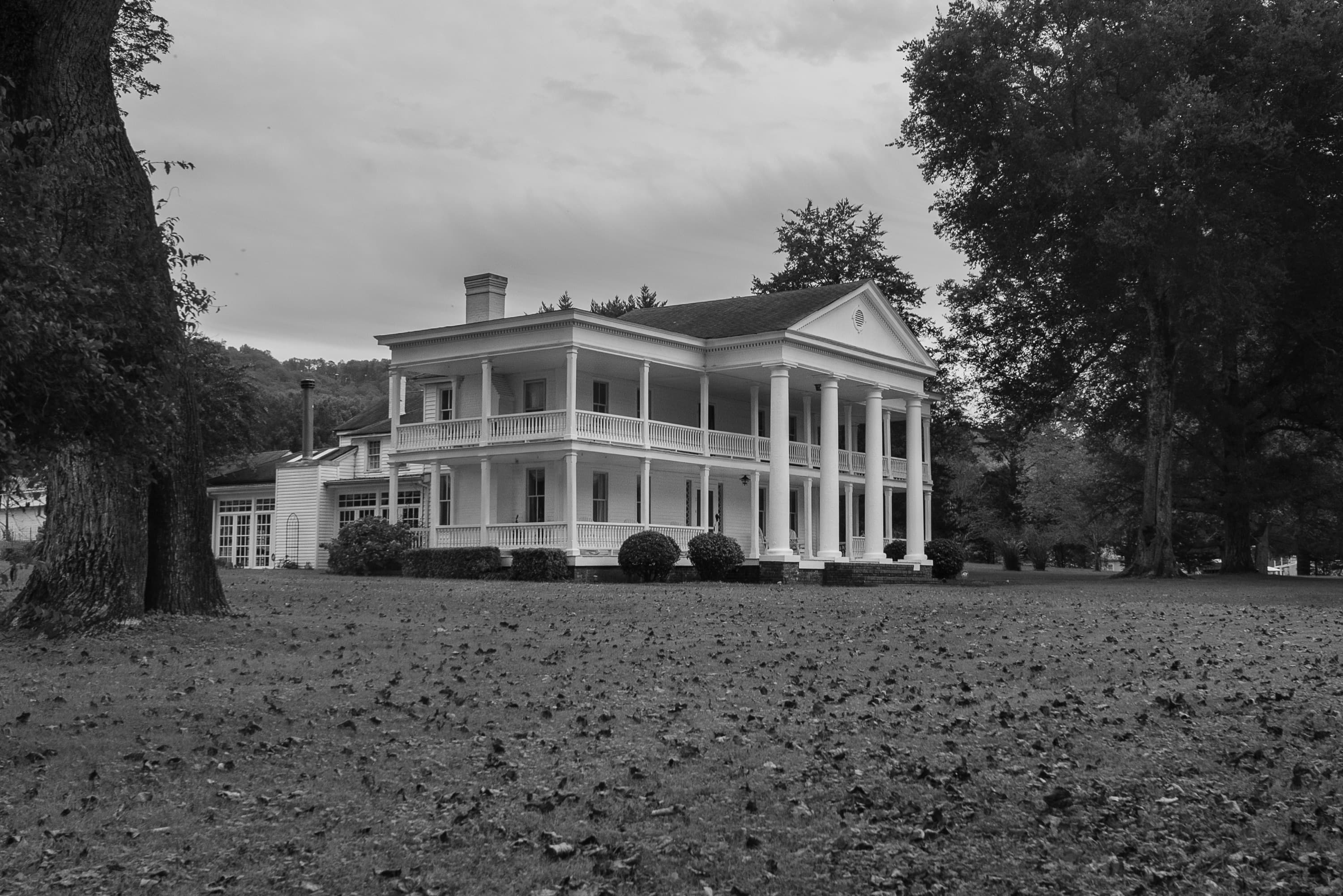 Photography: JD Crane A columned historic house beneath old trees on an overcast day